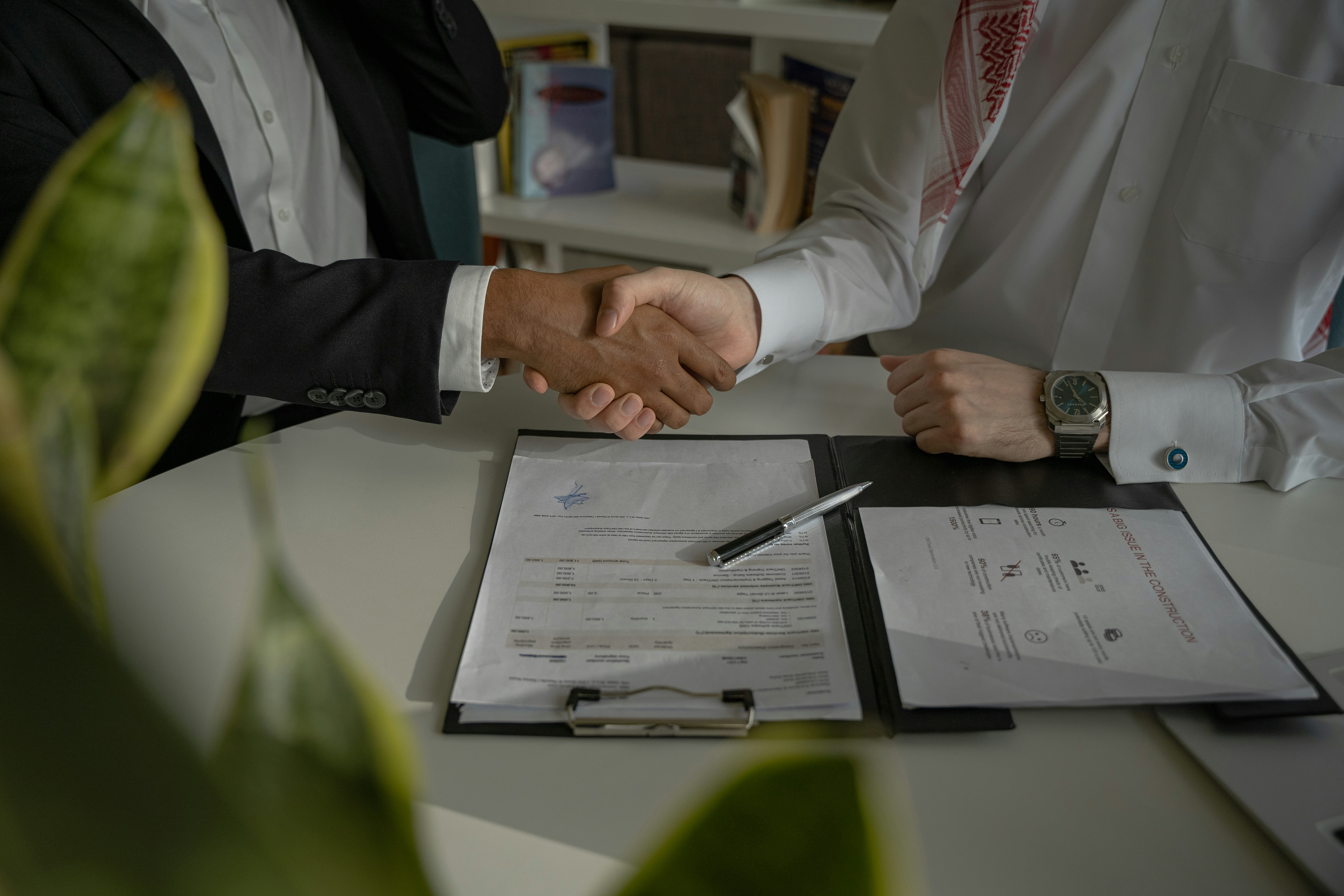 two-people-shaking-hands-over-a-piece-of-paper - amina-atar (unsplash)./pho